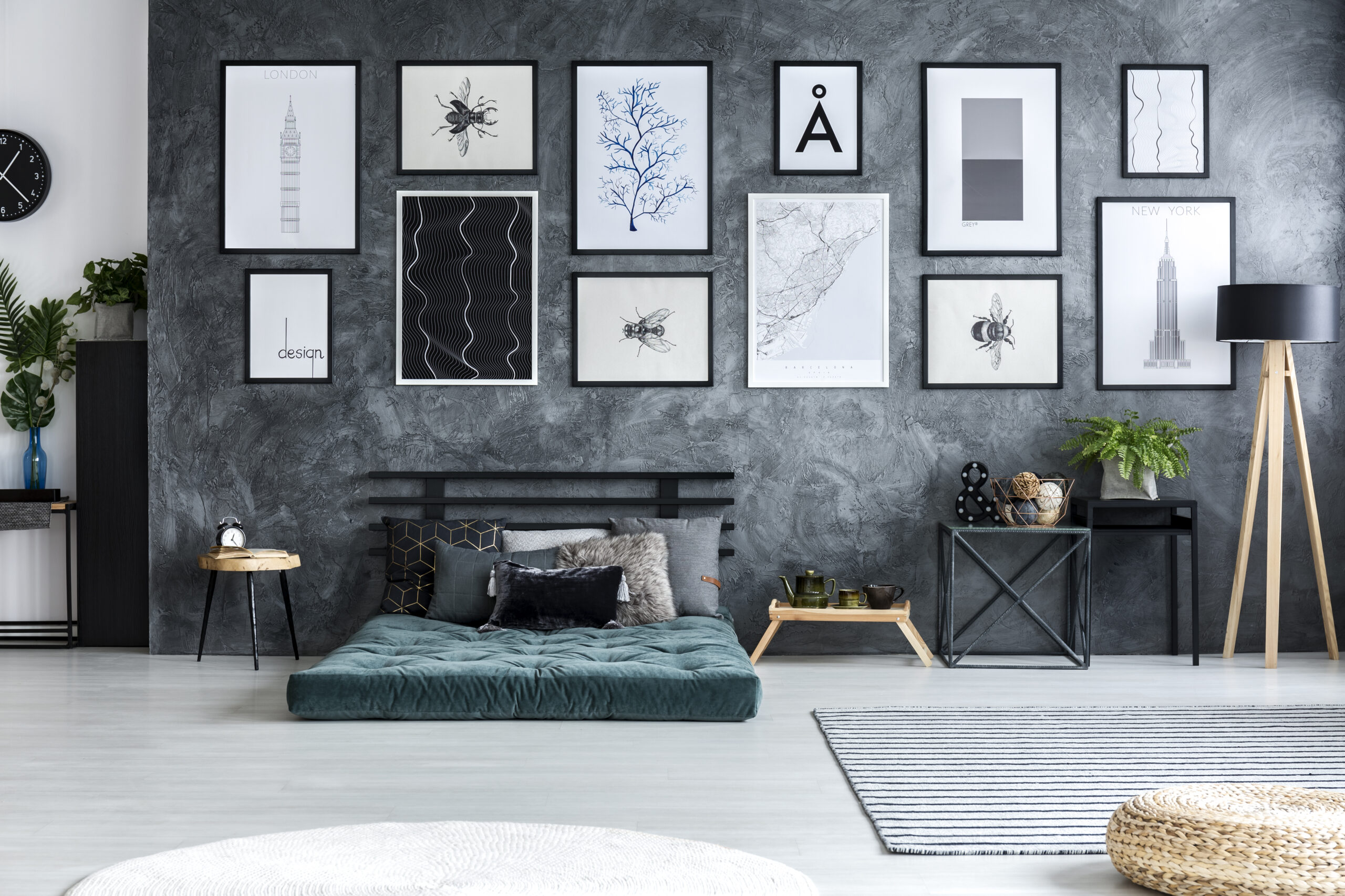 Green mattress against concrete wall with gallery of posters in