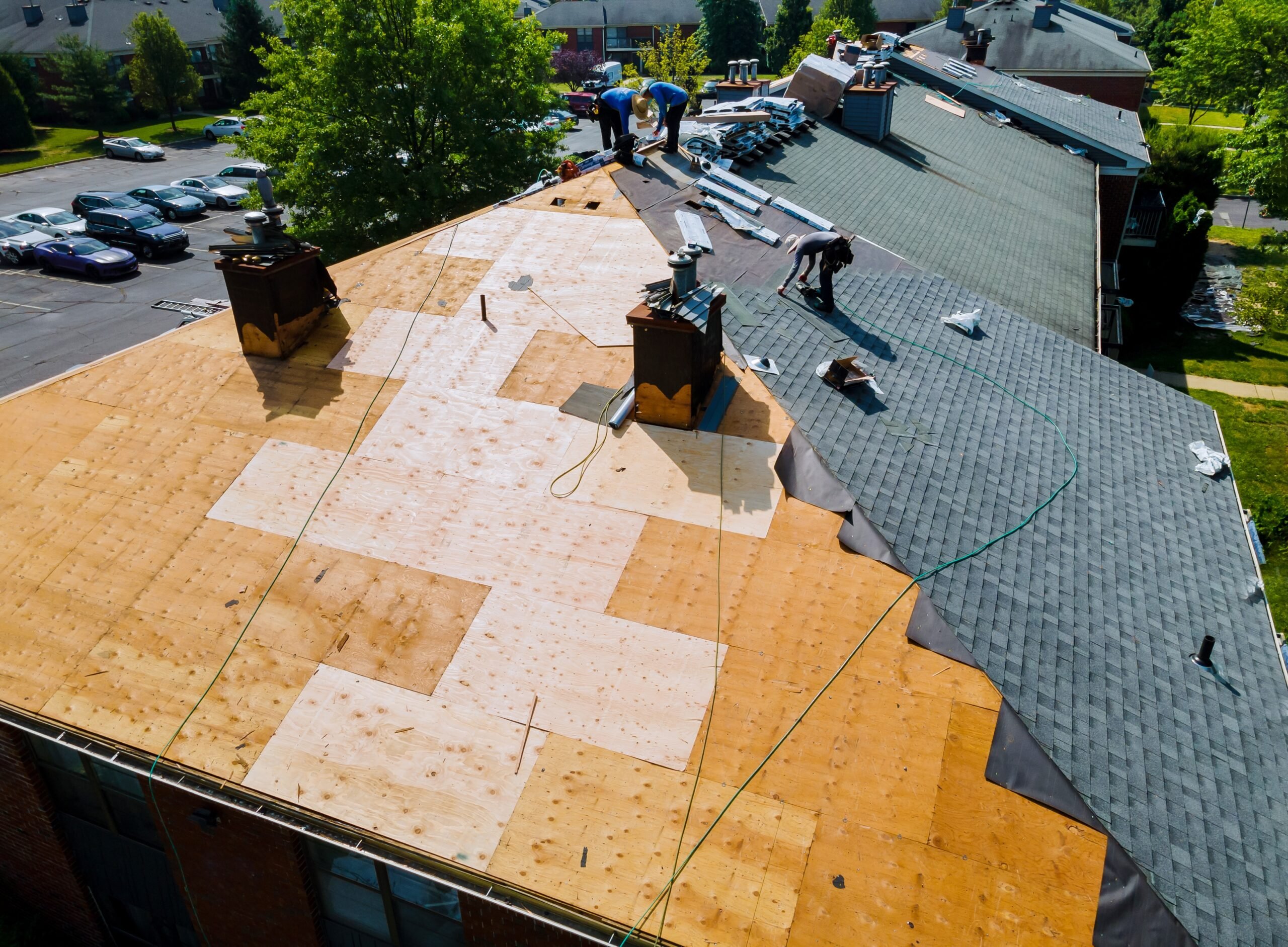 Handy Andy roofing contractor repairs old roof and installs new shingles of an apartment building in Seattle WA.