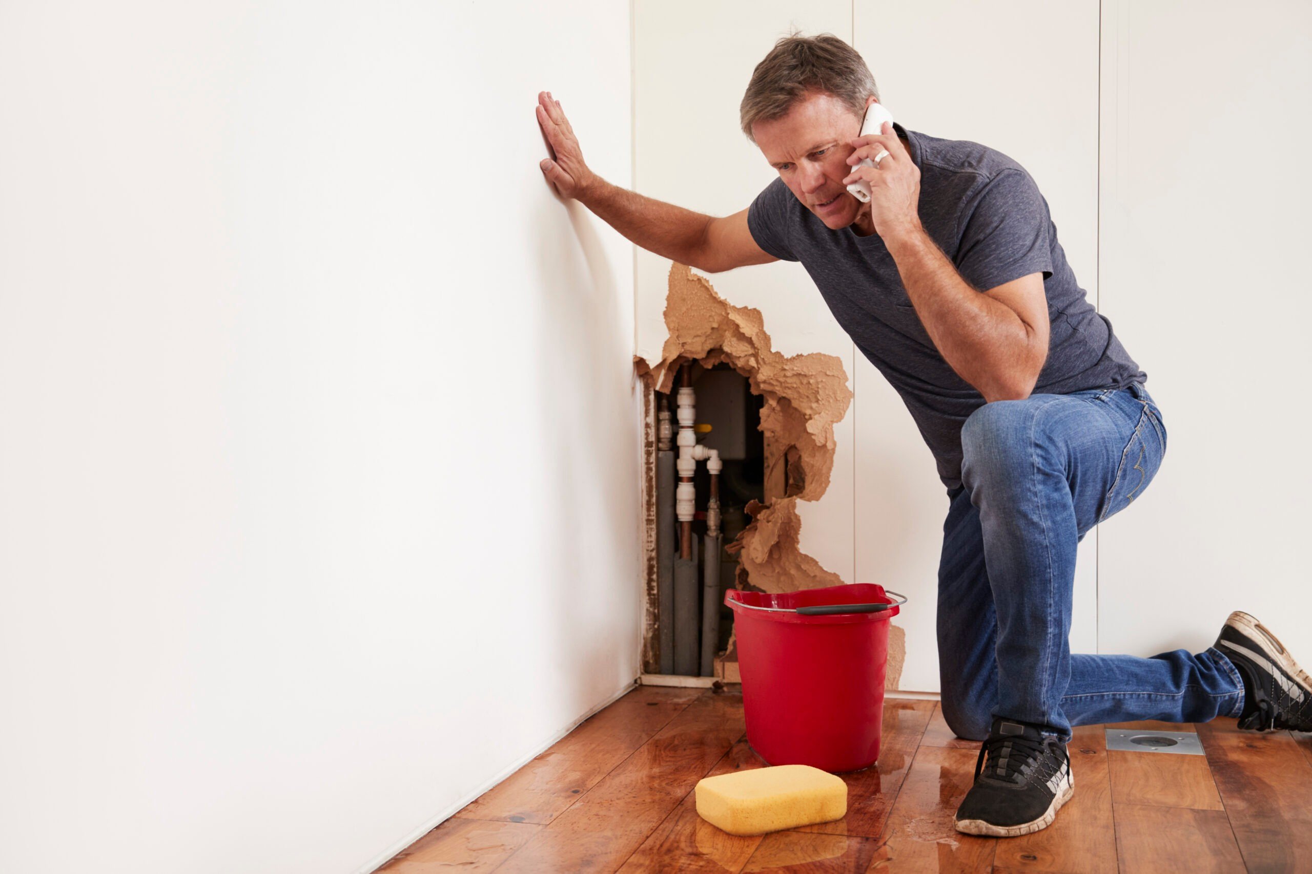 A man calling Handy Andy Restore and Repair to send out a certified plumber and IICRC-certfiied technicians to address a burst pipe.